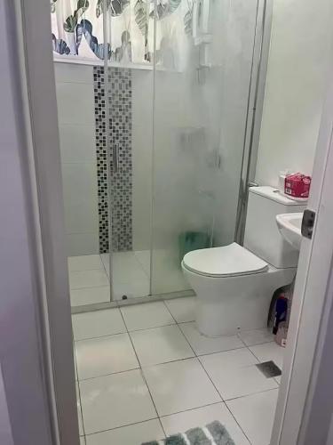 a bathroom with a shower with a toilet and a sink at M&Js Place in Cebu City