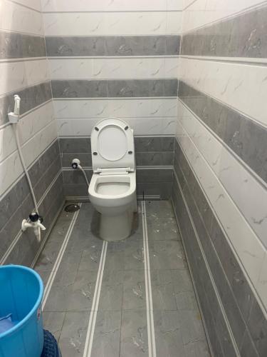 a bathroom with a toilet in a tiled room at VISHNU DATTA HOMESTAy in Bandanwāda