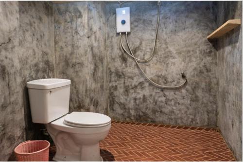a bathroom with a white toilet in a room at Lanta Sunny House in Ko Lanta
