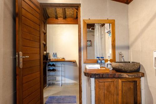 a bathroom with a sink and a mirror at Umah Jati Villa in Gianyar