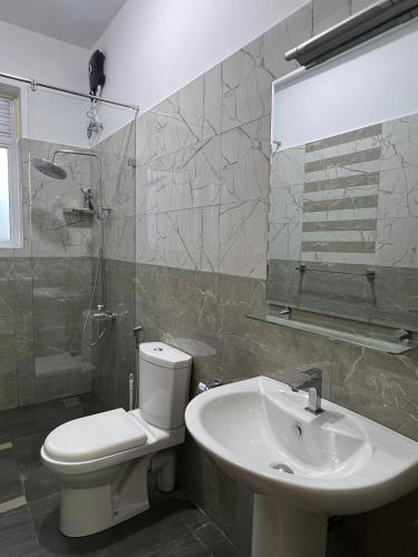 a bathroom with a toilet and a sink and a mirror at EZ Colombo Stay in Colombo