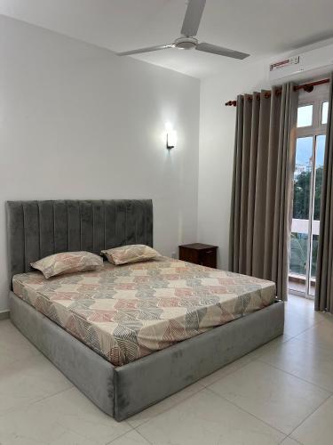 a bed in a bedroom with a ceiling fan at EZ Colombo Stay in Colombo