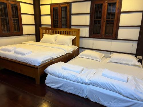 two beds sitting next to each other in a room at Mary's House Xiengthong in Luang Prabang