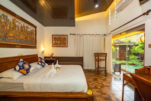 a bedroom with a bed with two cats on it at Sajjana House Bali By Magno in Nusa Dua