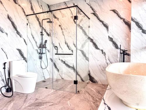 a bathroom with a glass shower and a sink at Villa Nuansa in Mantaak
