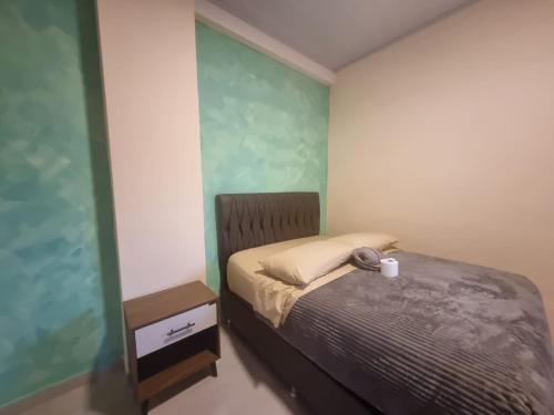 a small bedroom with a bed and a night stand at Residencial La Castilla in Quillacollo