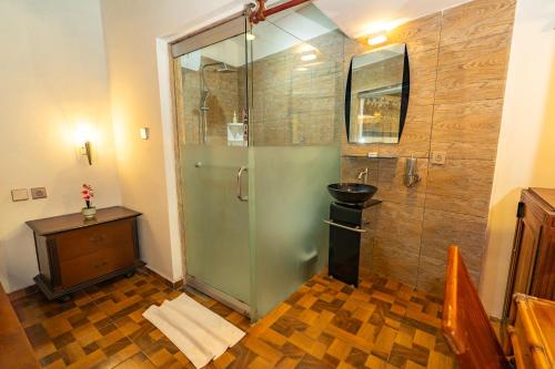 a shower with a glass door in a bathroom at Sajjana House Nusadua By Magno in Nusa Dua