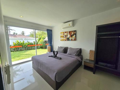a bedroom with a large bed and a large window at SAWAN Residence Pool Villas in Lamai