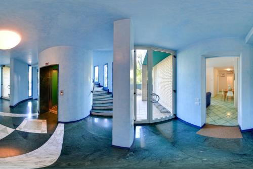 リッチョーネにあるStella Marinaの青い壁の客室とガラスドア付きの廊下