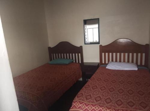 a room with two beds and a window at Alojamiento hostel constitucional in Sucre