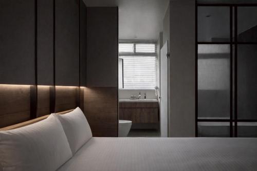 a bedroom with a bed and a bathroom with a sink at Guangfa Apartment in Tainan