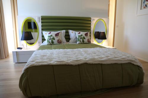 a bedroom with a large bed with a green headboard at Hotel Rural Quinta das Quintães in Penafiel