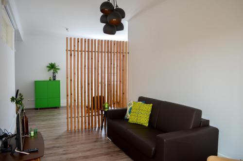 a living room with a black couch and a green cabinet at A Casa del Rei in Ribeira Grande