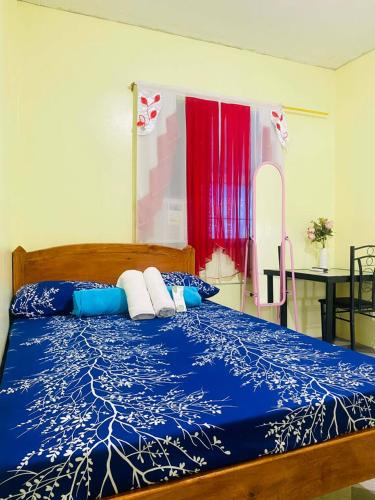 a bedroom with a bed with blue and white sheets at Landayan Traveller Inn in Baco Medio Island