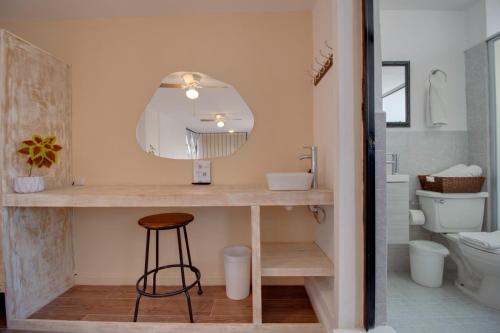 a bathroom with a counter with a stool and a mirror at Hotel Punto 79 in San Miguel de Allende