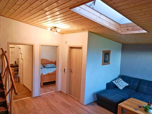 a living room with a blue couch and a skylight at Nachhaltiges Ferienhaus in Steinheim in Steinheim