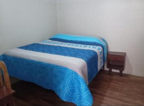 a blue and white bed in a room with a table at Alojamiento hostel constitucional in Sucre
