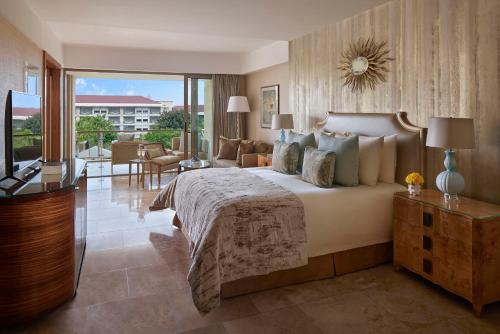 ein Schlafzimmer mit einem großen Bett und ein Wohnzimmer in der Unterkunft Mulia Resort in Nusa Dua