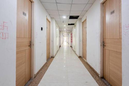 an empty hallway of an office building with wooden doors at Sunhaven Studio I Work & Leisure Stays I Near Expo Mart in Greater Noida