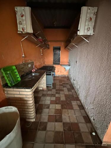 an empty kitchen with a tiled floor and counters at Chácara sol nascente in Suzano