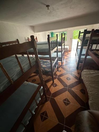 a room with several bunk beds and a tiled floor at Chácara sol nascente in Suzano