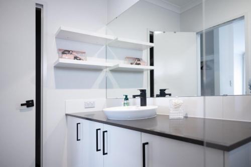 a white bathroom with a sink and a mirror at Serene Escape Near The Vines & Swan Valley in Upper Swan