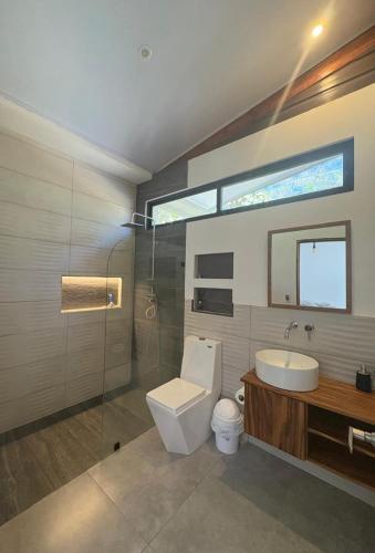 a bathroom with a toilet and a sink and a mirror at Mystica in Playa Avellana