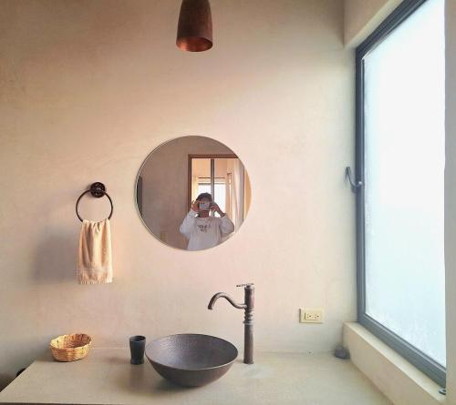 a person taking a picture of a sink in a bathroom at Casita Atardecer in Todos Santos