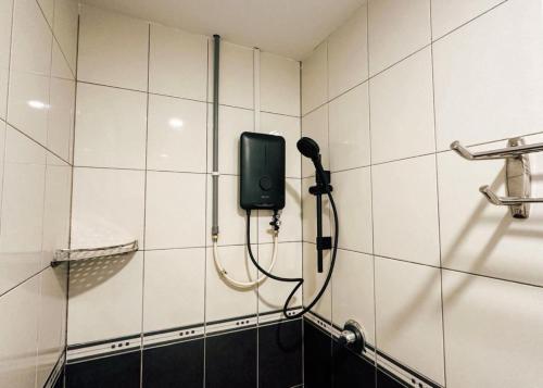 a bathroom with a phone on a tiled wall at Swing & Pillows - Sentul Jalan Ipoh Kuala Lumpur in Kuala Lumpur
