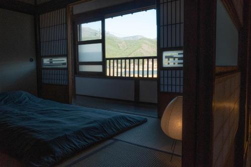 a bedroom with a bed and a view of a mountain at 古民家宿torch in Fujikawaguchiko