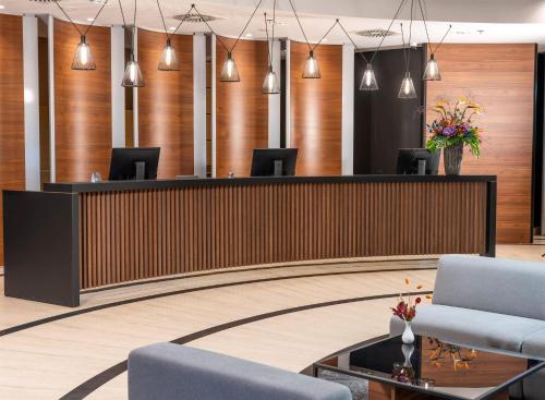 a lobby with chairs and a reception desk at Doubletree by Hilton Ljubljana in Ljubljana