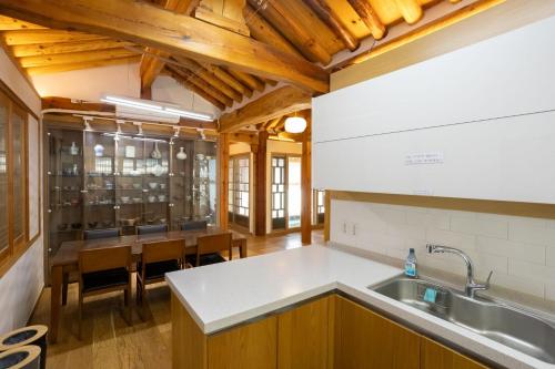 a kitchen with wooden ceilings and a dining room at HakMinJae Hanok Stay in Seoul