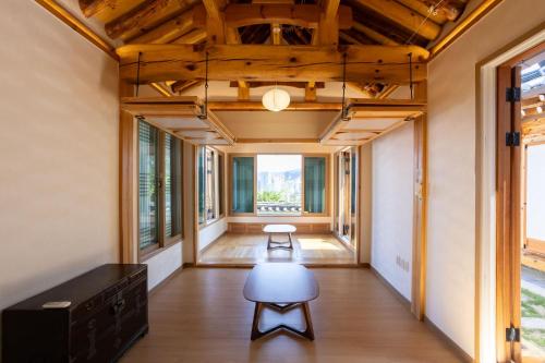 a hallway with a table and a chair in a house at HakMinJae Hanok Stay in Seoul