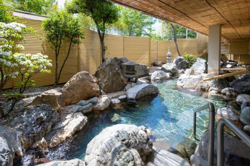a pool of water with rocks in a yard at Mt Fuji Hanayagi no Sho Keizan in Fuefuki