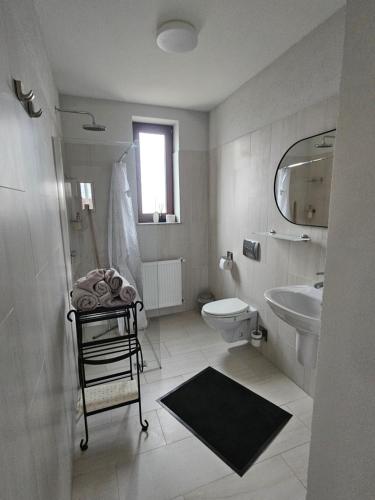 a white bathroom with a sink and a toilet at Jois Apartments Periam in Periam