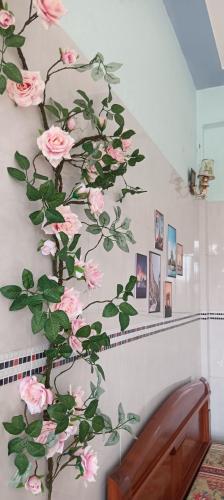 a wall mural of pink roses on a wall at LUNA House in Hue