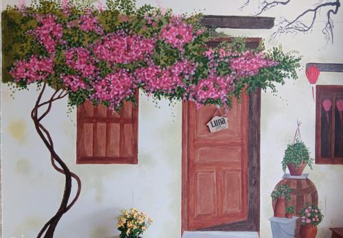 a painting of a door and a tree with pink flowers at LUNA House in Hue