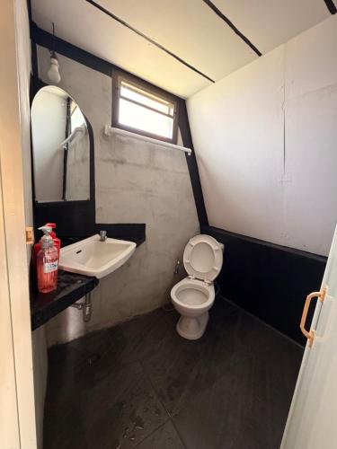 a bathroom with a toilet and a sink and a mirror at พีเจ คิงดอม โฮมสเตย์ in Buriram