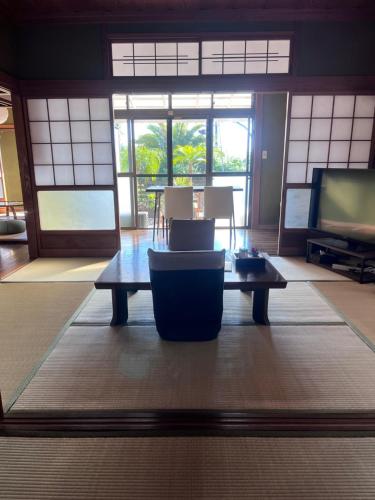 a living room with a coffee table and a tv at Vacation rental PIGGY's Nichinan in Nichinan