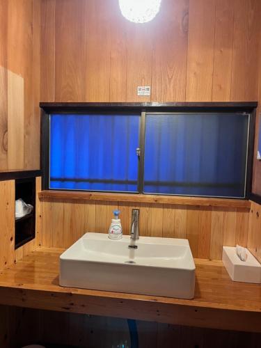 a bathroom with a sink and a blue window at Vacation rental PIGGY's Nichinan in Nichinan