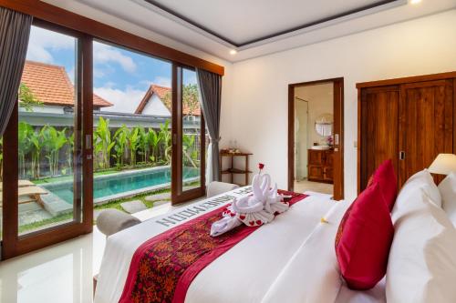 a bedroom with a large bed and a pool at Umah Uwa Villa Ubud in Tegalalang
