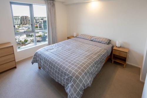 a bedroom with a bed and a large window at Modern City Pad, 1-Min to Showgrounds in Brisbane