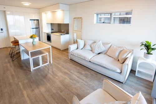a living room with a couch and a table at Modern City Pad, 1-Min to Showgrounds in Brisbane