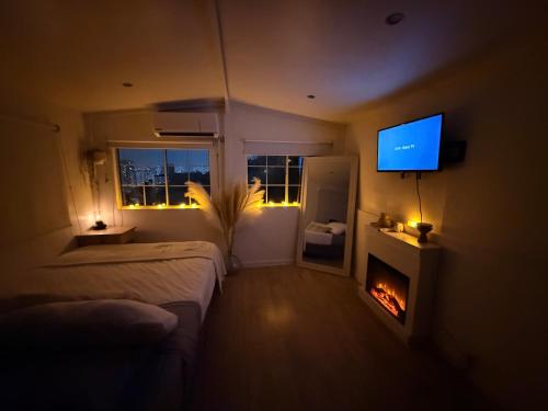 a bedroom with two beds and a television and a fireplace at Casita Garden n chill in Tijuana