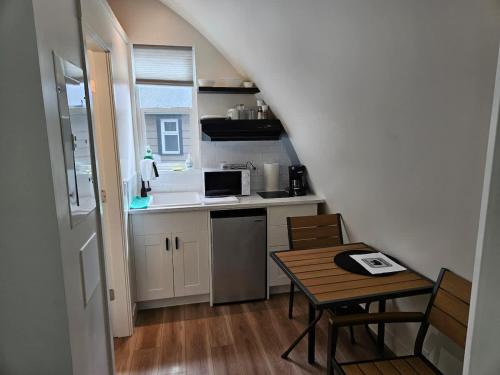 a small kitchen with a table and a sink and a stove at Stylish Cabin Escape w - Kitchenette & Ensuite Bath in Port Renfrew