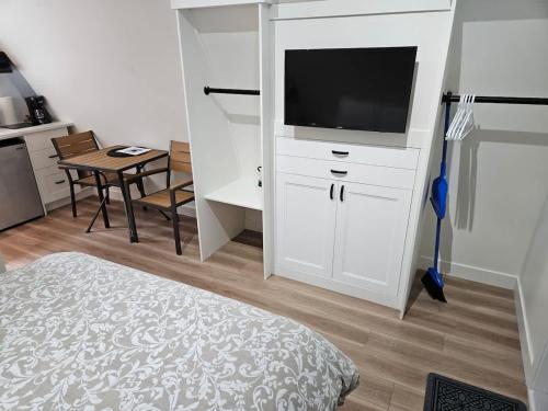 a bedroom with a white cabinet with a television on it at Stylish Cabin Escape w - Kitchenette & Ensuite Bath in Port Renfrew