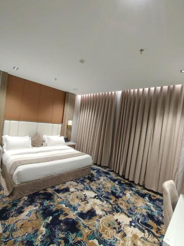 a bedroom with a large bed and a large rug at فندق بوابة ابها in Khamis Mushayt