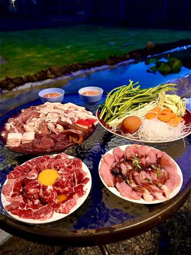 a table with different types of food on it at พีเจ คิงดอม โฮมสเตย์ in Buriram
