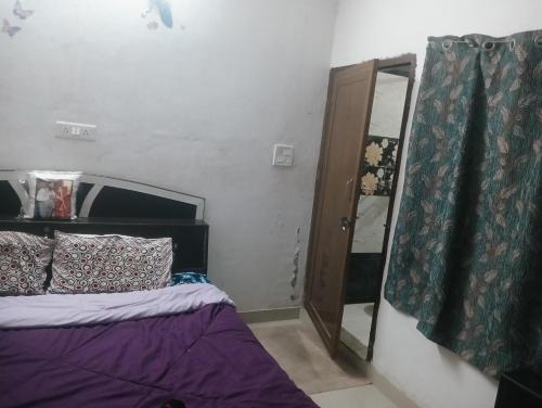 a bedroom with a bed and a mirror next to a door at Rajwaniya home in Jaipur