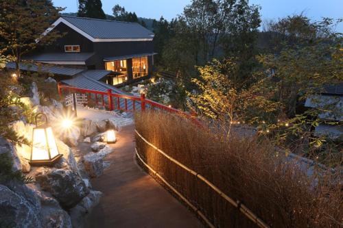 a house with lights in the snow at night at Gekkoju Kurokawa in Minamioguni